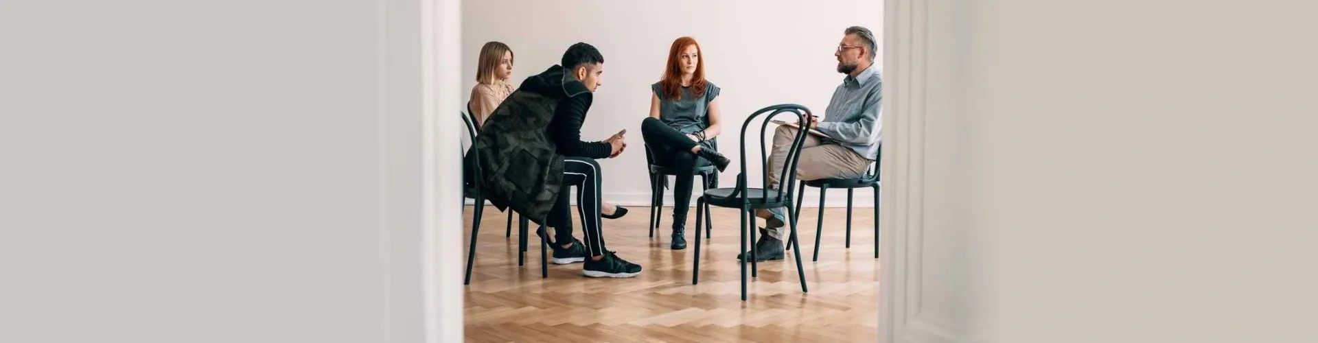 A group of people sitting in chairs on the floor.